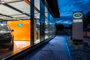 Außenaufnahme Autohaus Landrover mit Schaufenster und PKW links und Logo und Schriftzug rechts