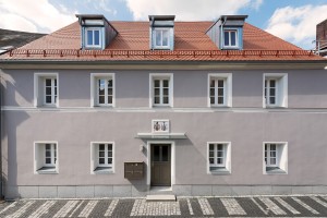Graues Wohnhaus in Kemnath mit zehn weißen Fenstern an Weg mit Kopfsteinpflaster