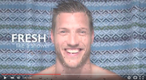 Portait eines lächelnden Mannes in Dusche mit Wassertropfen an Linse.Feigefotodesign