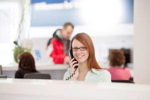 Mitarbeiterin Portrait am Servicetelefon. Feigfotodesign
