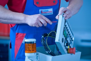 Industriefotografie Close-Up Mitarbeiter schraubt an Bedienfeld für Maschine. Feigfotodesign