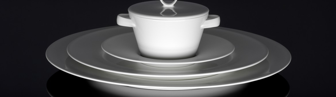 Werbefotografie Fotograf Oberfranken Oberpfalz weißes Porzellanservice aufeinander gestapelt auf dunkler Glasfläche. Feigefotodesign