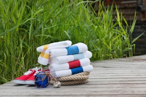 Bunte Handtücher in maritimen Farben der Serie PORTO von Feiler Chenille neben Schiffstau
