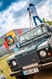 Fotograf Alexander Feig mit Stativ fotografiert Gebäude von Schwarz Elektromotoren. Feigefotodesign