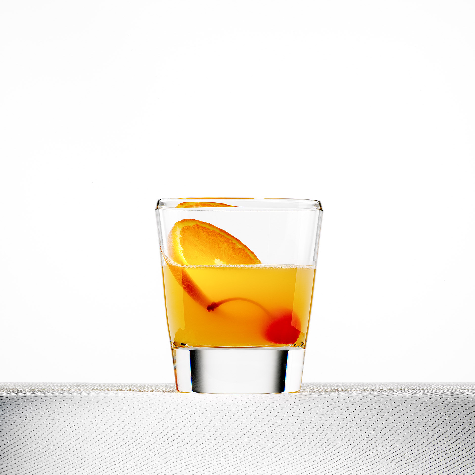 Produktfotografie Werbefotografie FotoStudio Oberfranken Whiskeyglas mit orangefarbenem Getränk und Obst. Feigefotodesign