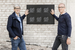 Fotograf Alexander Feig und Jürgen Frischmann stehen vor Backsteinwand Feigefotodesign